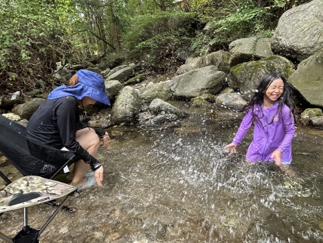Mother and daughter having fun by the creek
